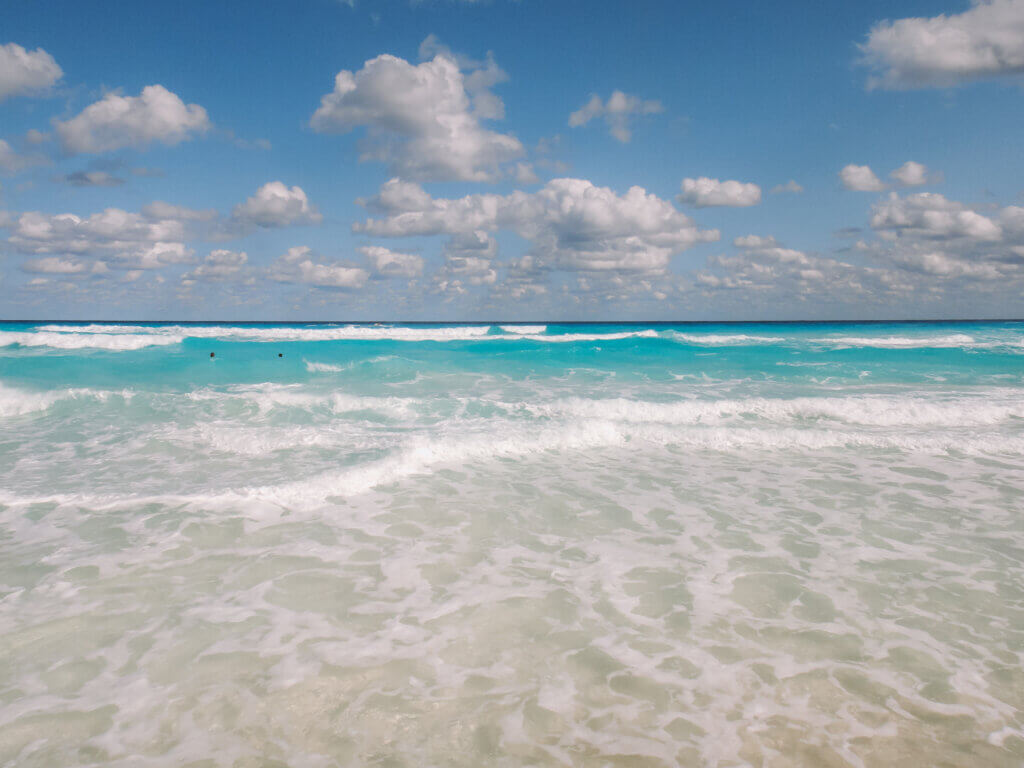 Turquoise Caribbean Sea water and white sand beach in Cancun, Mexico