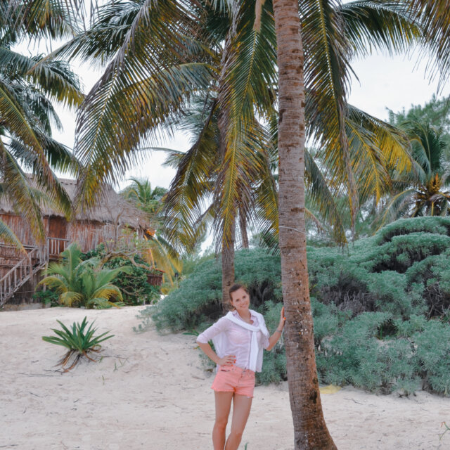 A girl on the beach by the palm tree