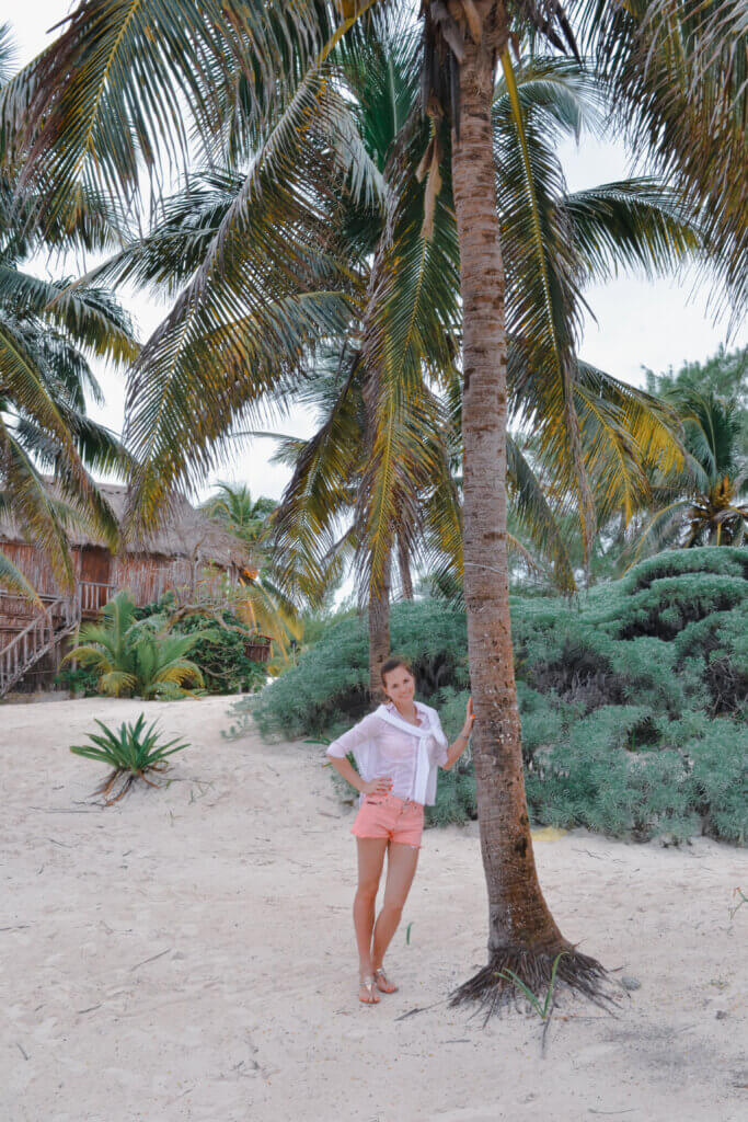 A girl on the beach by the palm tree