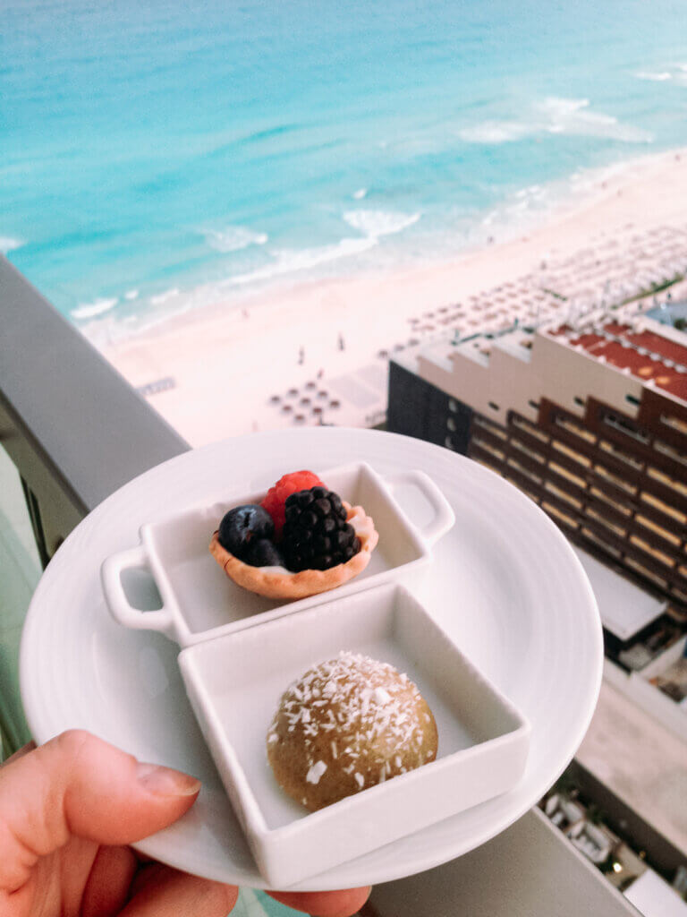 Small treats in a plane on the balcony with a view of a white beach in Cancun, Mexico